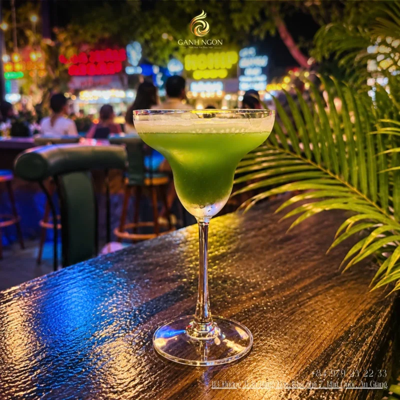 Ly cocktail xanh mát trên quầy bar gỗ Gánh Ngon